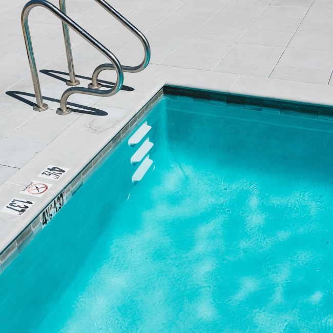 blue swimming pool with ladder vy_cVJCAVG0-unsplash-milkovi_650.