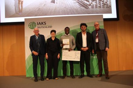 5 Leute auf der Bühne, mit Urkunde und Check