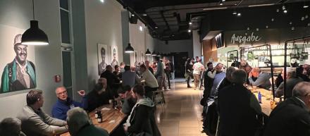 viele Menschen sitzen an Tischen und essen