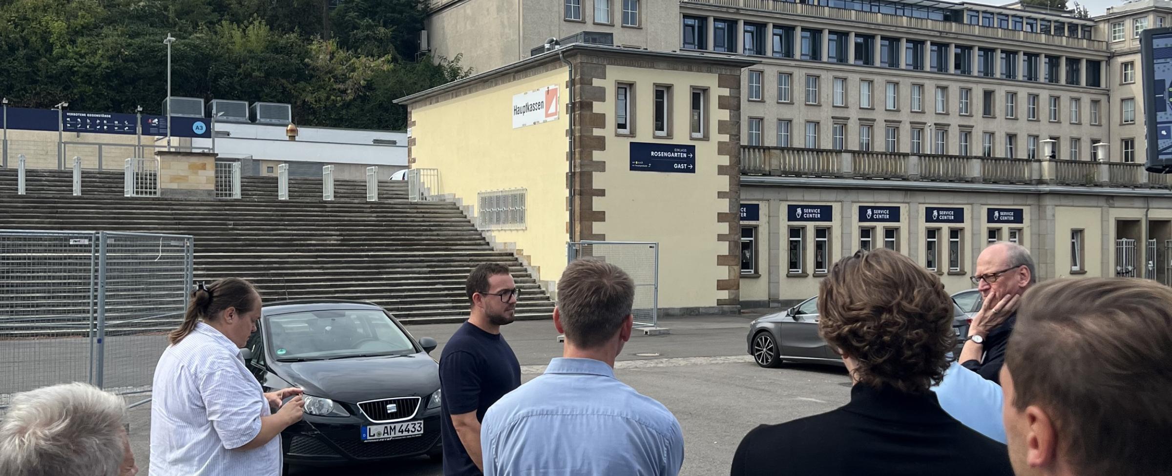 Menschen von hinten, im Hintergrund RB Leipzig