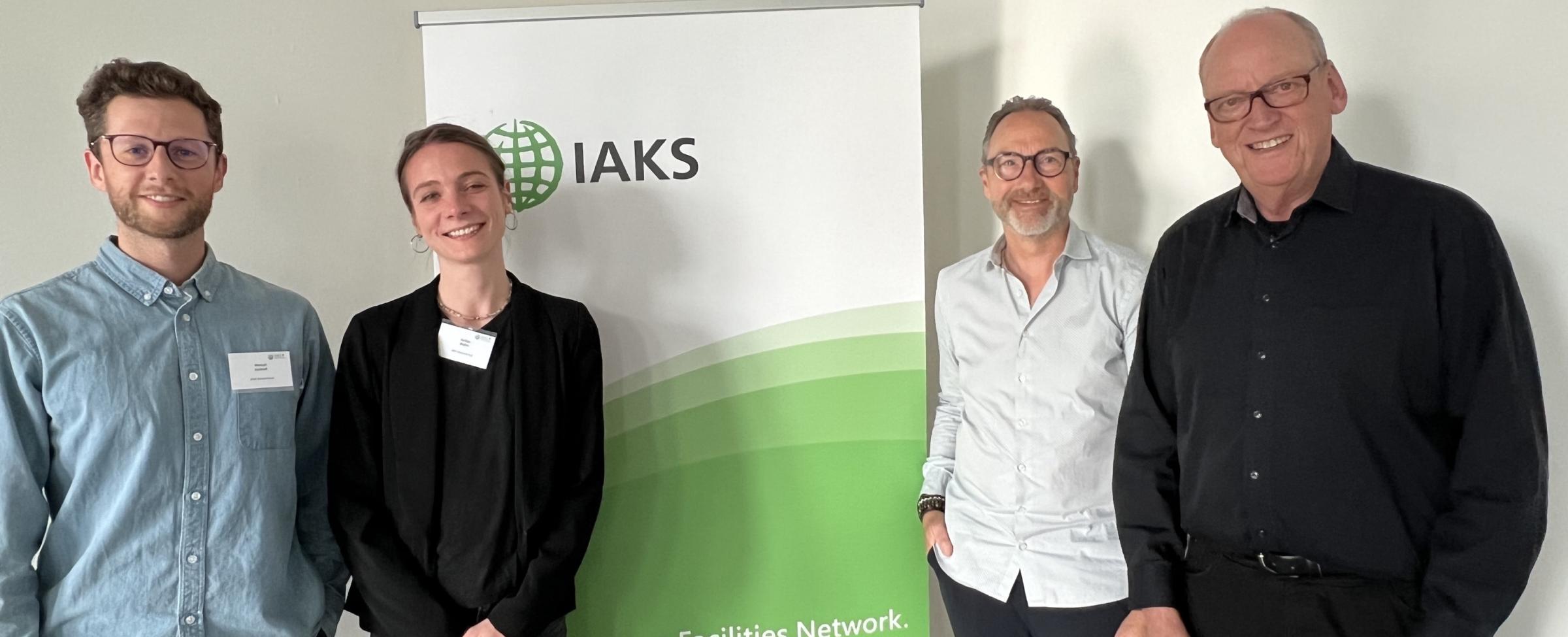 4 Personen vor IAKS Schild