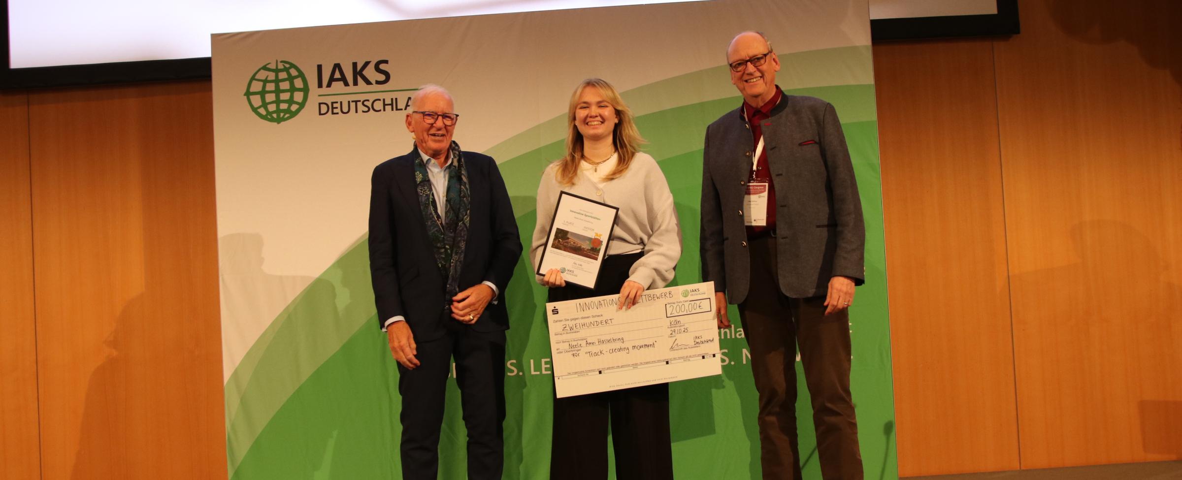 3 Leute schütteln Hände auf Bühne