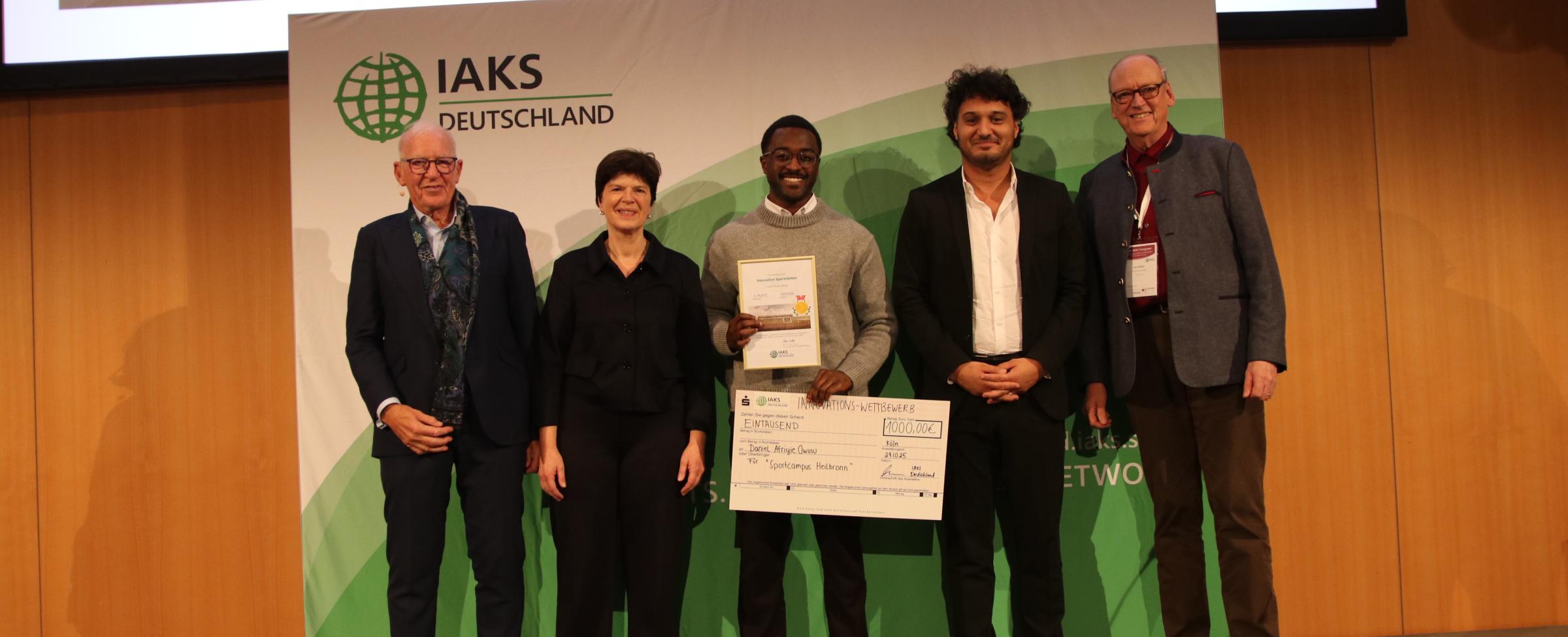 5 Leute auf der Bühne, mit Urkunde und Check