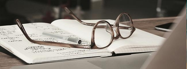 Brille auf aufgeklapptem Buch