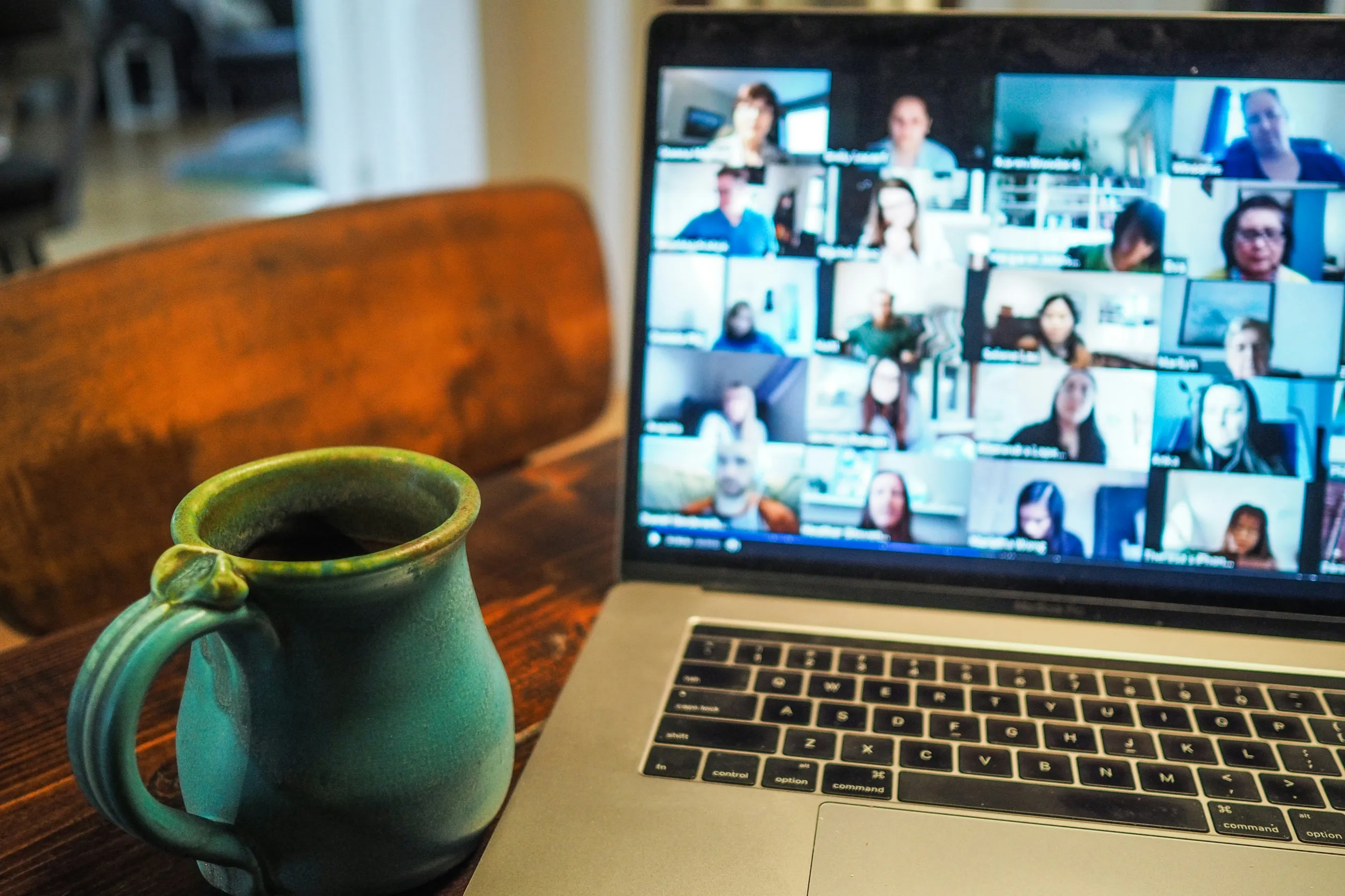 laptopo mit online meeting auf dem Screen, daneben Tee Tasse