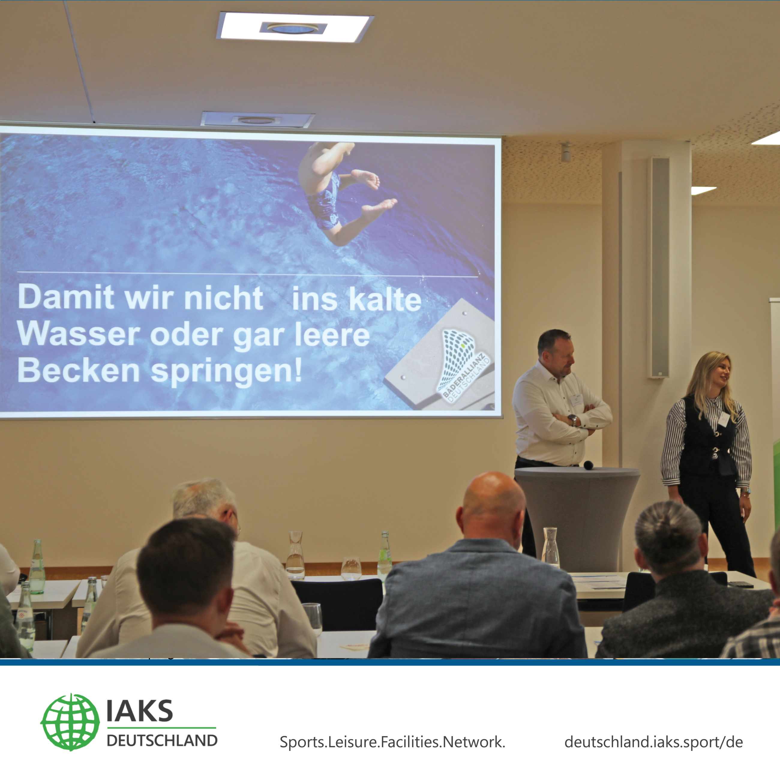 Miriam Kuhn und Thomas Baum präsentieren vor Sitzungssaal