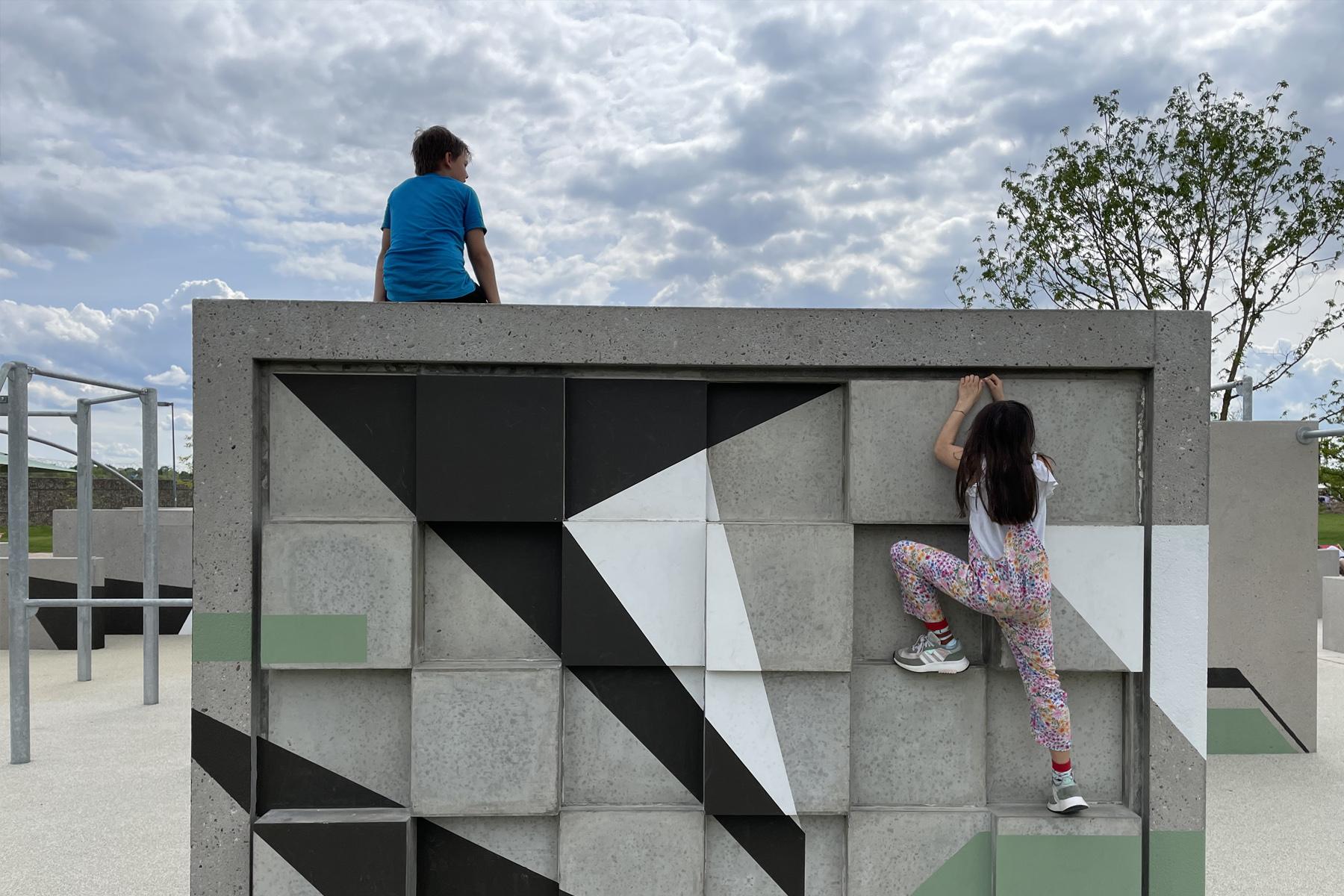 Kinder turnen an Parcour-Wand