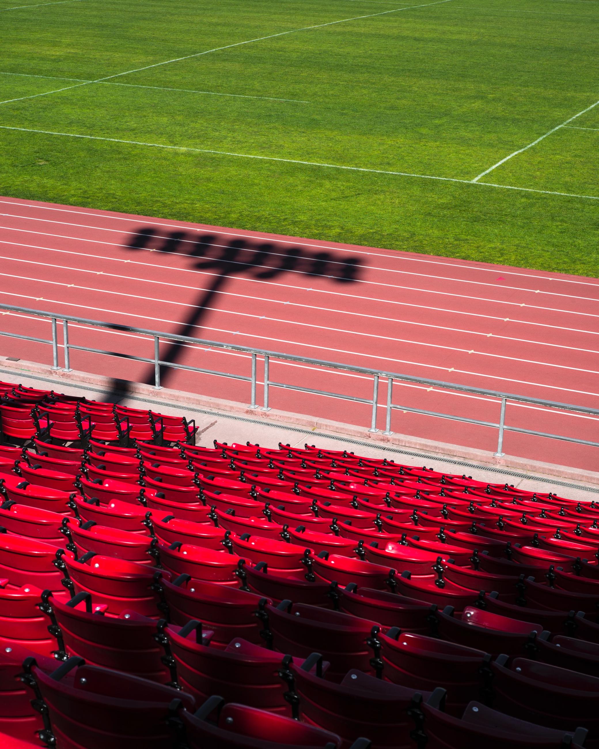 View into sport stadium with the seats, the track and some grass